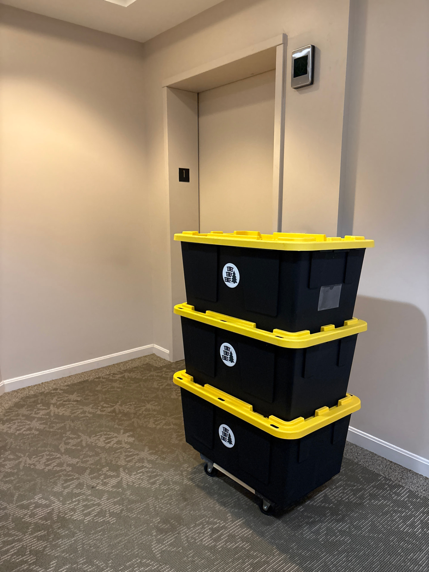 Maine Moving Totes on a dolly being rolled into an elevator during a delivery